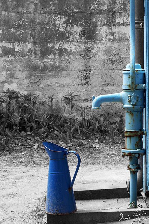 Pompe à eau manuelle et broc bleu