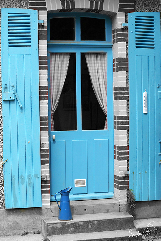Porte d'entrée d'une maison bleu et broc bleu